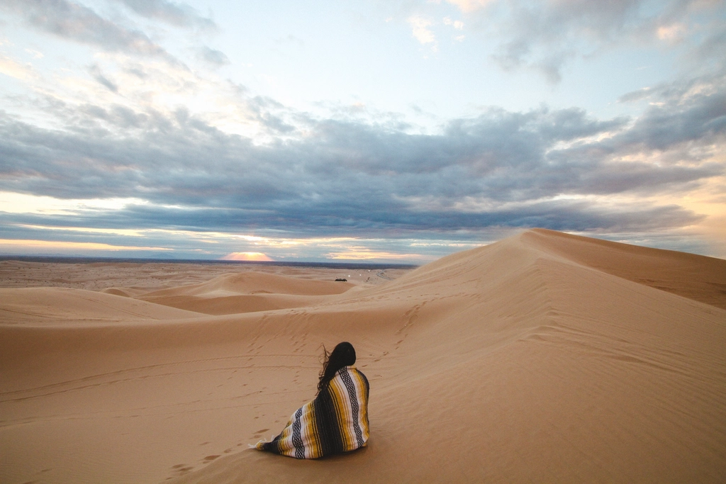 Woman sits Aztec blanket watching